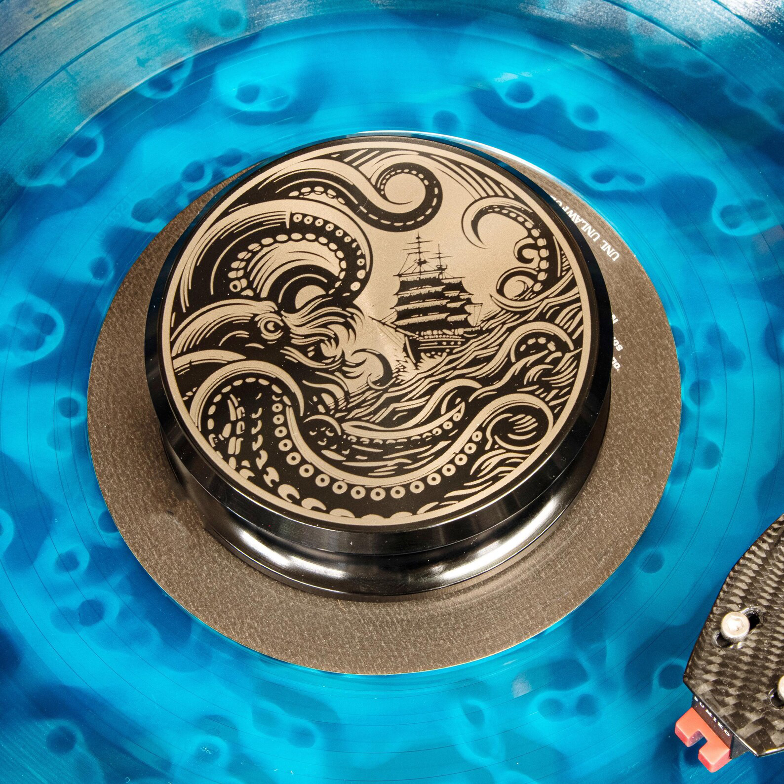 Kraken engraved aluminum record weight on blue vinyl